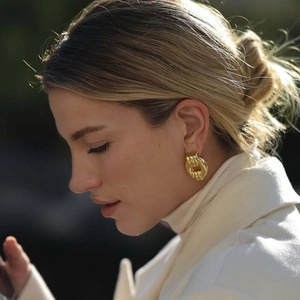 Elegant 18k gold plated stainless steel twisted hoop earrings worn by a model