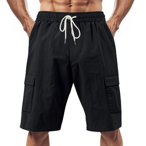 Detail of black cargo shorts featuring elastic drawstring waist and side flap pockets