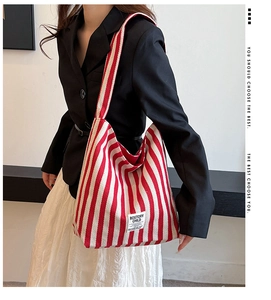 Close-up of red and white striped canvas tote bag worn on shoulder for stylish casual use