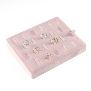 Detail of pink velvet jewelry tray with slots showing multiple elegant fashion rings