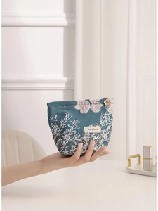 Elegant teal jacquard floral cosmetic bag with a gold flower zipper pull for travel