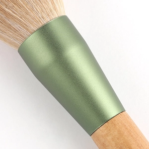 Macro detail of soft powder brush bristles with green ferrule and wooden handle