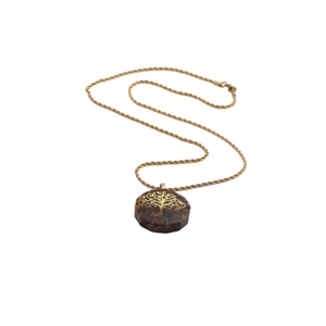 Detail of life tree pendant necklace with brown resin stones and golden rope chain
