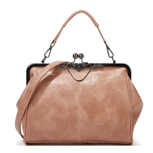 Close-up of brown leather handbag with metal frame clasp and detachable shoulder strap
