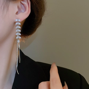 Detail of silver leaf earrings with zirconia tassels on model for a refined look