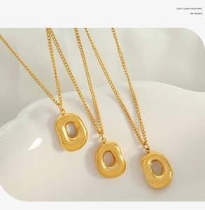 Detailed view of three 18k gold plated hollow irregular pendant necklaces on display stand