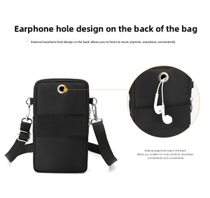 Detail of the headphone jack design on the back of the black nylon mini crossbody phone bag
