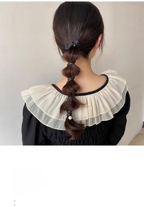 Détail d'un élastique à cheveux noir avec nœud et perle pour queue de cheval