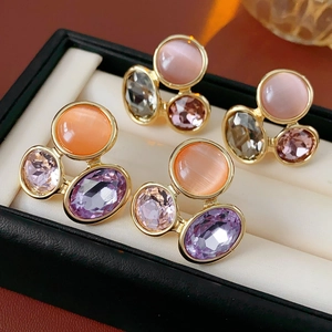Detailed view of vintage oval earrings with pink cat eye stones and faceted crystals