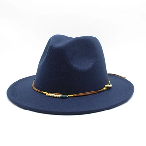 Dettaglio di un cappello fedora in lana blu scuro con fascia intrecciata e perle