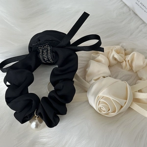 French vintage rose scrunchie and satin bow hair tie with pearl charm on fur background