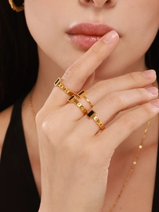 Detail of three 18K gold plated stainless steel rings with black square mother of pearl