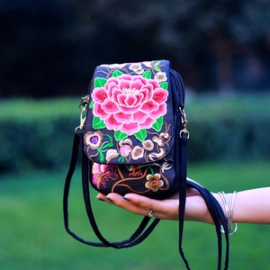 Close-up of ethnic floral embroidery and fine texture on a mini crossbody phone bag