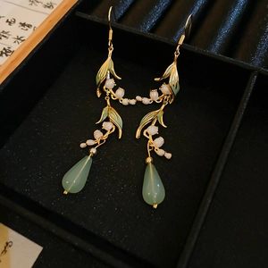 Detail view of Lily of the Valley earrings with enamel leaves and green teardrop beads