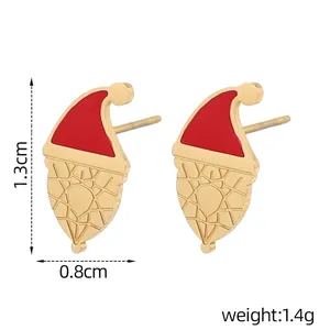 Détail de boucle d'oreille bonnet de Noël avec émail rouge et finitions dorées