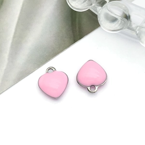 Detail shot of two pink enamel heart charms with silver metal edges for DIY jewelry making
