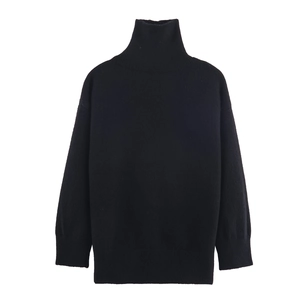 Détail d'un pull en maille noir à col roulé montrant les poignets côtelés et le tissu