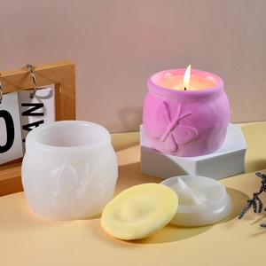 Vista de detalle del molde de silicona y tarro con relieve de mariposa para velas
