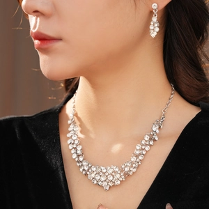 Close-up of geometric diamond-set necklace and earrings set worn by a model