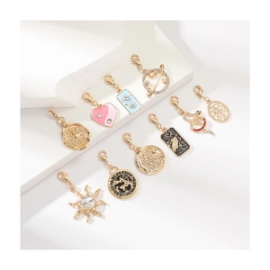 Set of 10 gold tarot pendants with enamel and rhinestones on white stands