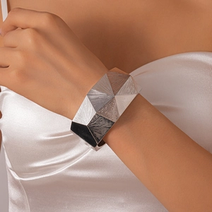 Detailed view of silver wide geometric cuff bracelet with radial textured pattern on wrist