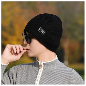 Close-up of black knit beanie with FARDi label and thick textured pattern details