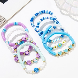 Detail view of 7-piece handmade clay bead bracelet set with mixed heart and flower charms
