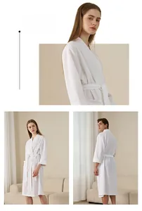 Macro detail of white waffle weave fabric on unisex bathrobe with belt and pockets