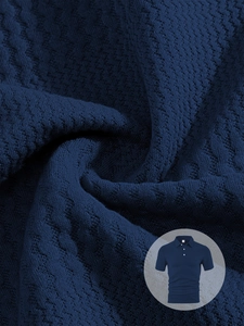 Detail of navy blue polo shirt featuring textured jacquard knit fabric and button collar