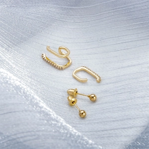 Detail view of 3-piece gold ear cuff set with pavé cubic zirconia on silk fabric