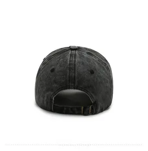 Detail view of the black washed denim baseball cap featuring an adjustable bronze buckle