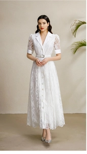 Détail d'une robe en dentelle blanche avec col tailleur, ceinture et textures délicates