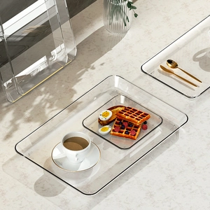 Minimalist transparent acrylic tray set with gold rim on marble tabletop for home decor