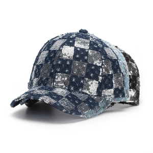 Close-up of sequined checkerboard pattern and distressed denim on baseball cap detail