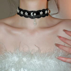 Détail du collier choker en dentelle noire avec étoiles perles, lune et pendentif
