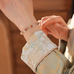 Vue détaillée d'un bracelet en perles de cristal de quartz coloré au poignet d'une femme