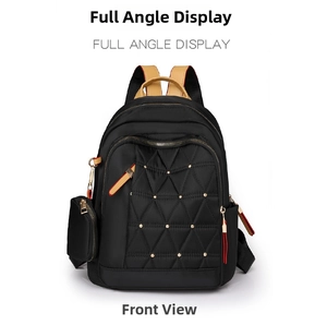 Vista frontal de mochila de nailon acolchado negro con tachuelas doradas y detalles en cuero