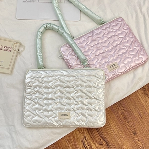 Detail of heart quilted laptop sleeve with metallic finish and soft mint green handles