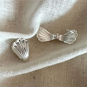 Macro shot of S925 sterling silver shell earrings with detailed textured vertical stripes
