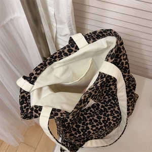 Detail view showing interior pocket and beige lining of leopard print canvas tote bag