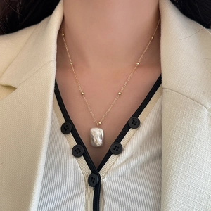 Close-up of a French vintage baroque pearl necklace on a delicate gold chain for women