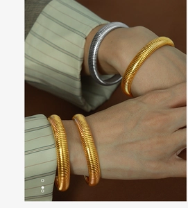 Macro shot of 10mm retro striped gold and silver titanium steel spiral texture bangles