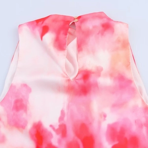Detalle de vestido midi satinado tie-dye rosa con botón en cuello y abertura de gota