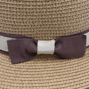 Macro detail of natural straw weave and ribbon bow on foldable sun hat for women