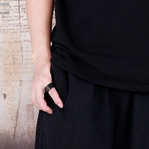 Detail of matte black rotatable stainless steel ring with numerals on thumb