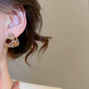 Close-up of vintage triangle stud earrings with amber and clear crystals on model