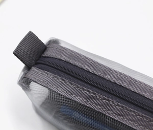 Detail of grey mesh pencil case showing fine texture and durable zipper with black handle