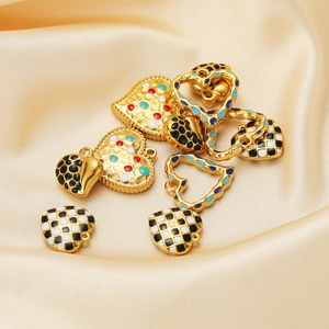 Close-up of enamel heart pendants in checkered and polka patterns on silk fabric