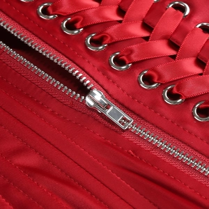 Vue macro détaillée du laçage en satin rouge et du zip métallique sur le vêtement