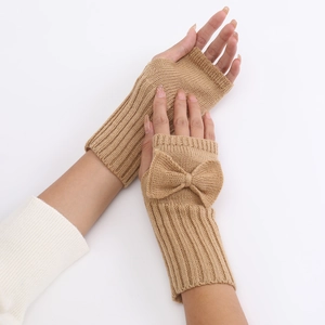Detail of camel knitted fingerless gloves featuring a delicate bow and ribbed wrist cuffs